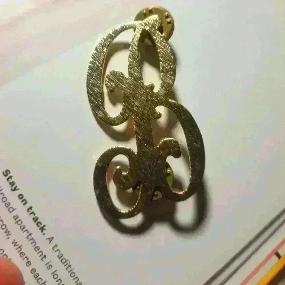 B, gold  lapel pin